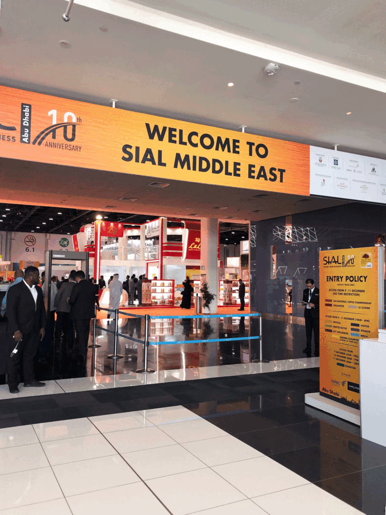 Entrance area of SIAL Middle East in Abu Dhabi, international food exhibition with visitors and trade professionals.