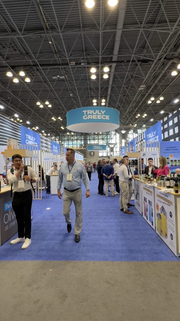 Greek pavilion aisle at the Summer Fancy Food Show 2025, with visitors walking through the “Truly Greece” section.